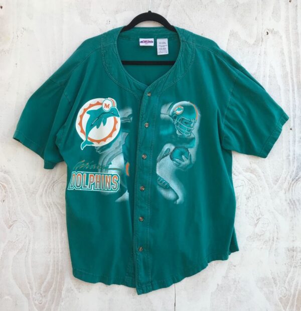 product details: MIAMI DOLPHINS SS BD JERSEY SCREENPRINT DOLPHIN LOGO AND CHARGING FOOTBALL PLAYER GRAPHIC 100% COTTON photo