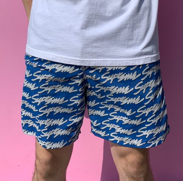 product details: SUPREME SIGNATURE SCRIPT LOGO WATER BOARD SHORTS ALL OVER TEXT WITH DRAWSTRING WAIST ZIP BACK POCKET AND MESH LINING photo