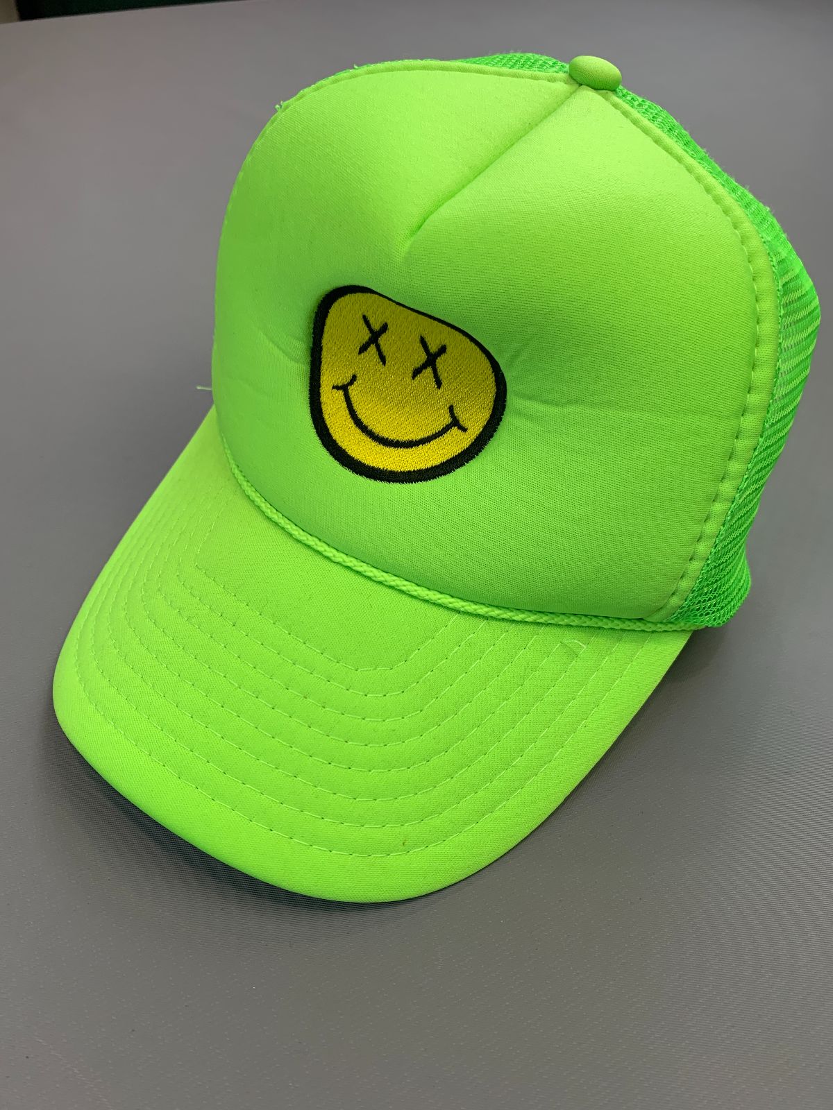 product details: EMBROIDERED DEAD SMILEY FACE DAYGLOW GREEN TRUCKER HAT photo