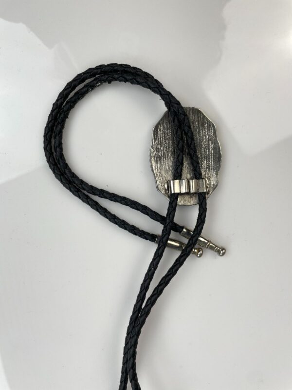 2-TONE ORNATE CROSSED PISTOL PLACARD BOLO TIE, BRAIDED LEATHER CORD