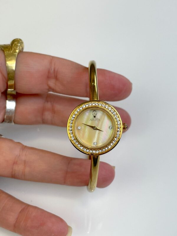 HIGH POLISHED GOLD HINGED BRACELET TIMEPIECE WATCH, CRYSTAL EMBELLISHED MOTHER OF PEARL FACE