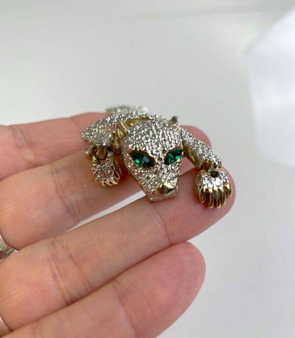 1990S SILVER ARTICULATED PANTHER OVER THE SHOULDER BROOCH, GREEN JEWEL EYES