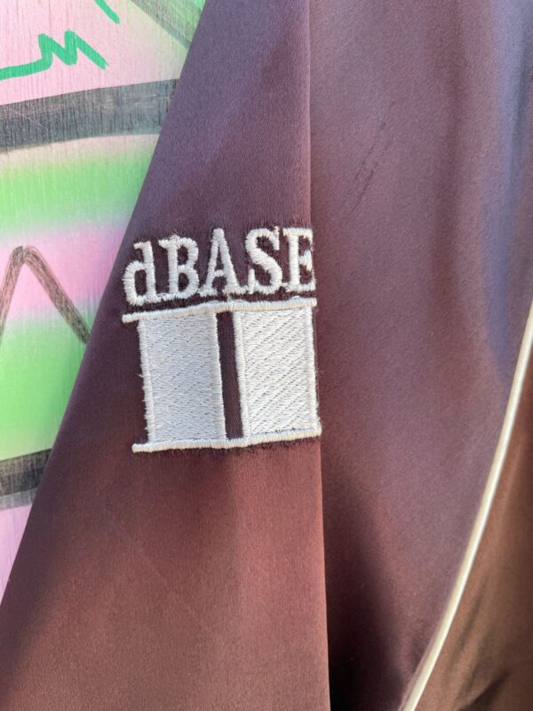 1980S EMBROIDERED ASHTON-TATE SOFTWARE COMPANY ACETATE ZIP-UP JACKET, SILVER PIPING