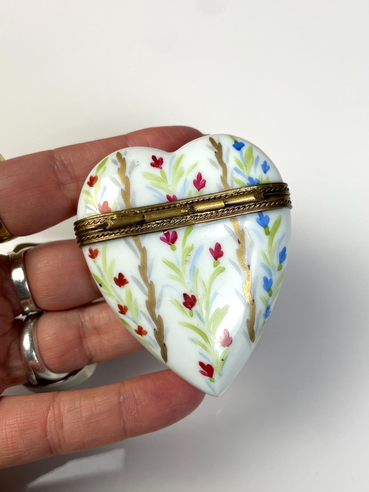 AMAZING! HAND PAINTED CERAMIC HEART KEEPSAKE BOX, DECORATIVE BRASS CLOSURE SIGNED BY ARTIST in WHITE, GOLD, RED, GREEN, BLUE
